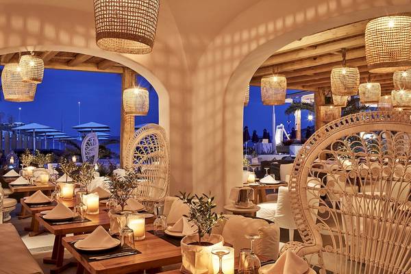 Innenbereich des Mykonos Ammos Hotels mit Tisch und Kerzen bei Nacht.