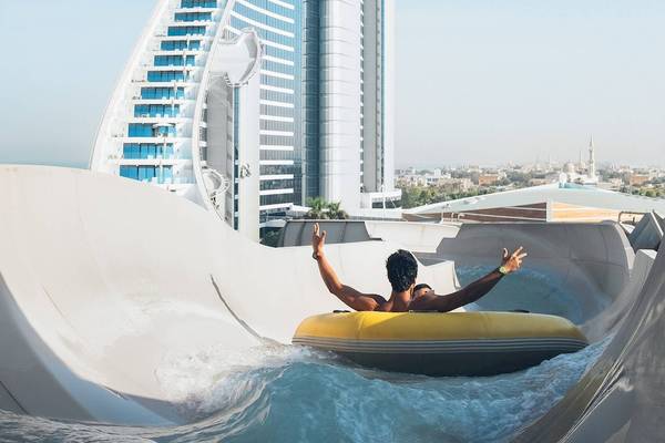 Mann in einem gelben Schlauchboot auf einer Wasserrutsche im Jumeirah Mina A'Salam