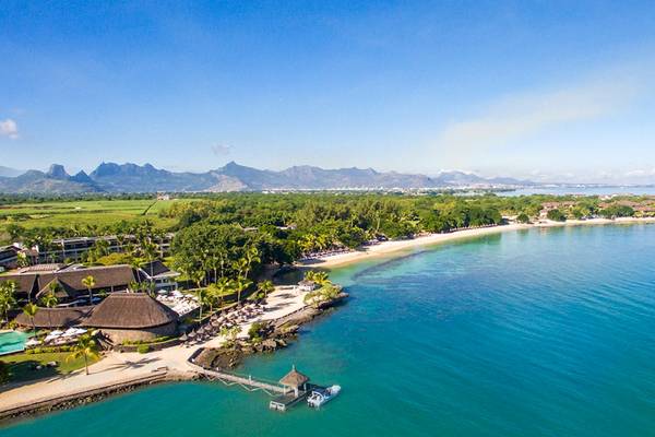 Luftaufnahme des Maritim Resorts & Spa Mauritius mit Strand, Gebäuden und Bergen im Hintergrund.