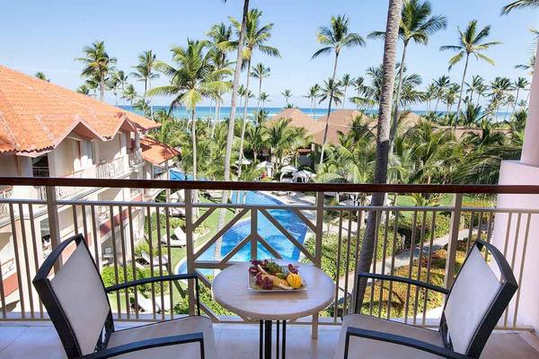 Balkon des Majestic Elegance Punta Cana mit Blick auf den Pool und das Meer.