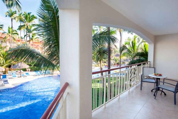 Aussicht vom Balkon des Majestic Elegance Punta Cana Hotels auf den Pool und Palmen