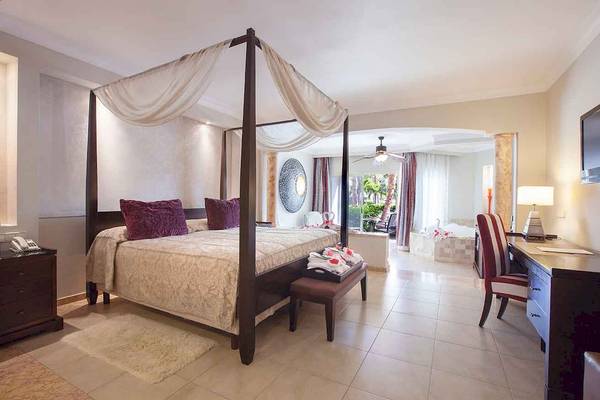 Hotelzimmer im Majestic Elegance Punta Cana mit Himmelbett, Schreibtisch und Badewanne