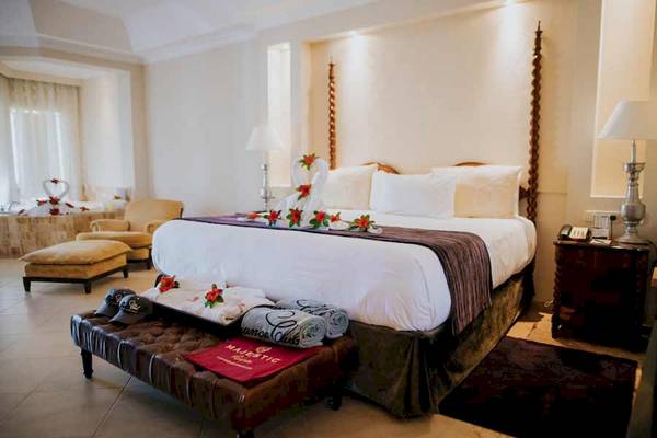 Luxuriöses Zimmer im Majestic Elegance Hotel in Punta Cana mit Bett, Dekor und Möbeln.