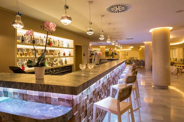 Die Bar im Grand Palladium Palace Ibiza Resort & Spa mit Marmortheke, Cocktails und Möbeln.
