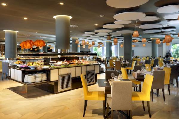 Restaurant im Grand Palladium Palace Ibiza Resort & Spa mit Buffet und Tischen.
