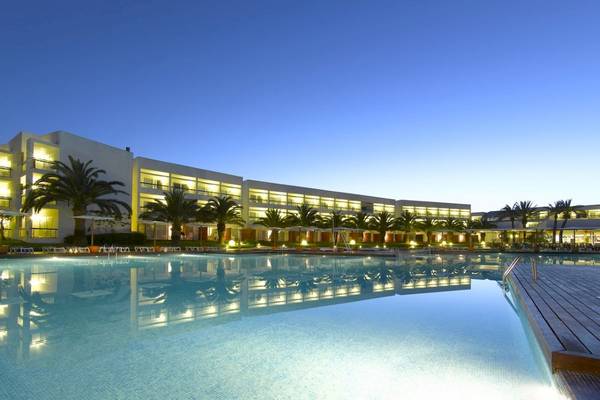 Außenpool des Grand Palladium Palace Ibiza Resort & Spa bei Nacht mit Palmen und Lichtern.
