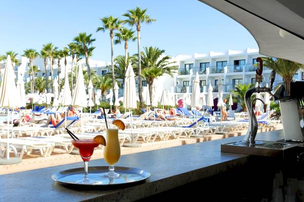 Poolbar im Grand Palladium Palace Ibiza Resort & Spa mit Cocktails und Sonnenliegen im Hintergrund
