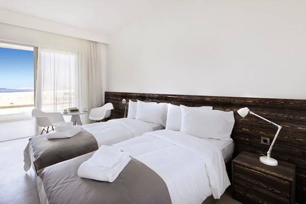 Zwei Betten mit weißen Laken in einem hellen Zimmer des Amphora Hotel & Suites