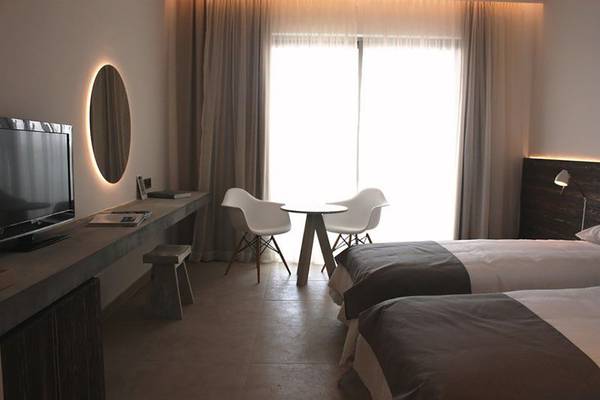 Schlafzimmer im Amphora Hotel & Suites mit zwei Betten, Tisch, Stühlen und Fernseher.
