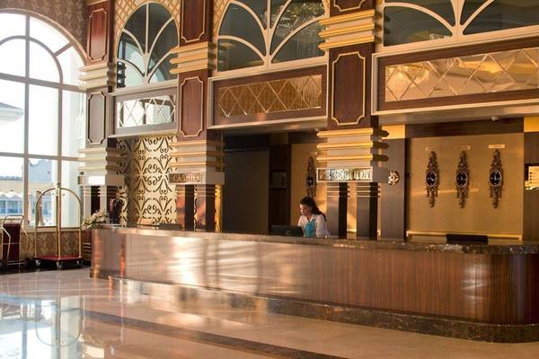 Empfangsbereich des Oz Hotels Side Premium mit einer Mitarbeiterin am Empfang.