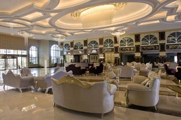 Hotellobby des Oz Hotels Side Premium mit weißen Möbeln und Kronleuchtern.