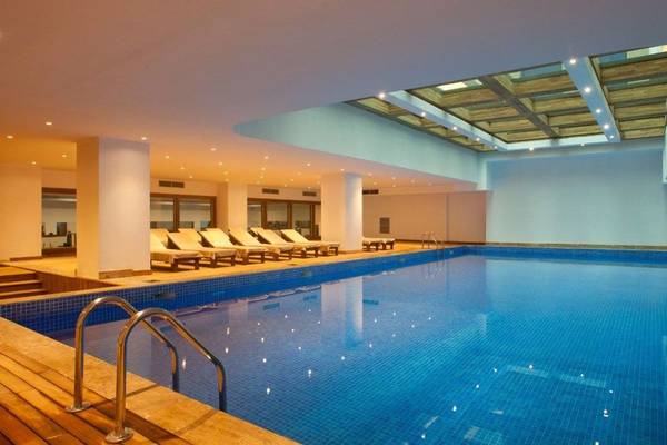 Innenpool im Oz Hotels Side Premium mit Sonnenliegen und beleuchteter Decke.