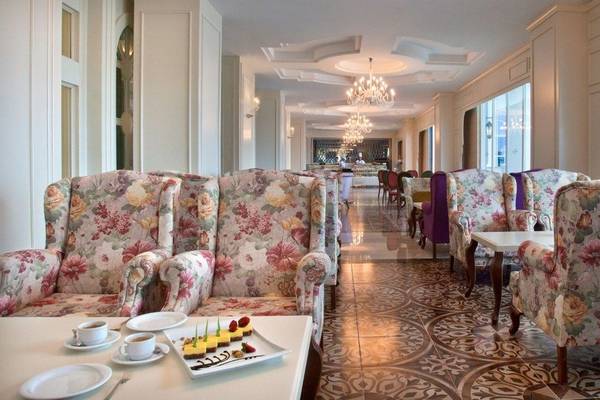 Oz Hotels Side Premium Innenbereich mit gemusterten Sesseln und Tischen im Lounge-Bereich.