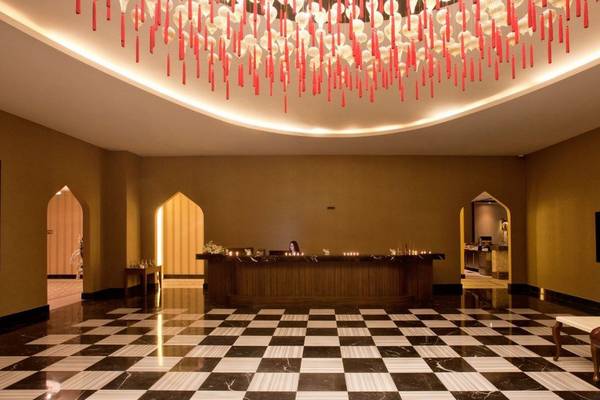 Empfangsbereich im Oz Hotels Side Premium mit Schachbrettboden und roter Dekoration.