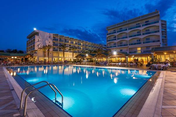 Außenpool des Apollo Beach Hotels bei Nacht mit Gästebereich und Beleuchtung.