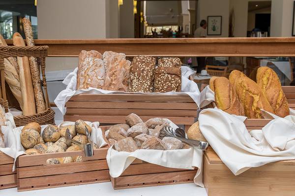 Brotbuffet im Apollo Beach Hotel mit verschiedenen Brotsorten in Holzkörben auf einem Tisch.