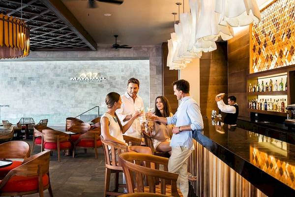 Gruppe von Gästen beim Barcelo Maya Grand Resort Hotel, die Cocktails an der Bar genießen.