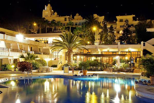 Nachtansicht des Hovima Panorama Hotels mit beleuchtetem Pool und Gebäuden im Hintergrund.