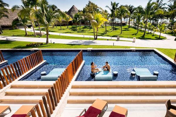 Zwei Personen entspannen in einem Poolbereich des Barcelo Maya Grand Resort.