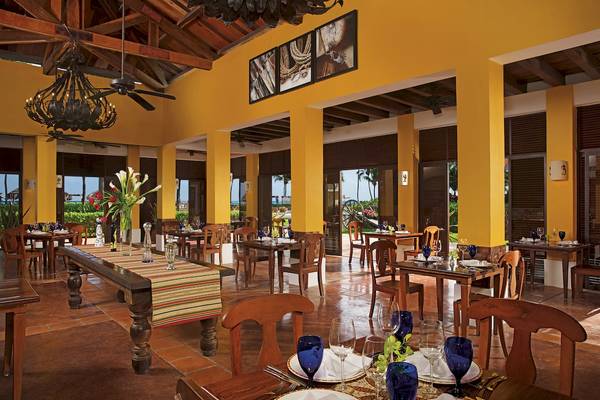Innenbereich des Restaurants im Dreams Tulum Resort & Spa mit blauen Gläsern und Tischdecken.