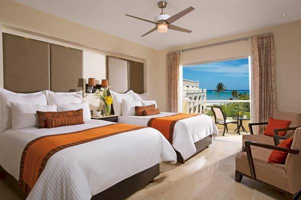 Zwei Betten mit Blick auf den Ozean im Dreams Tulum Resort & Spa