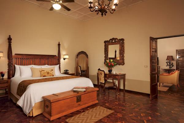 Zimmer im Dreams Tulum Resort & Spa mit Holzbett, Nachttischen, Dekor und Möbeln.