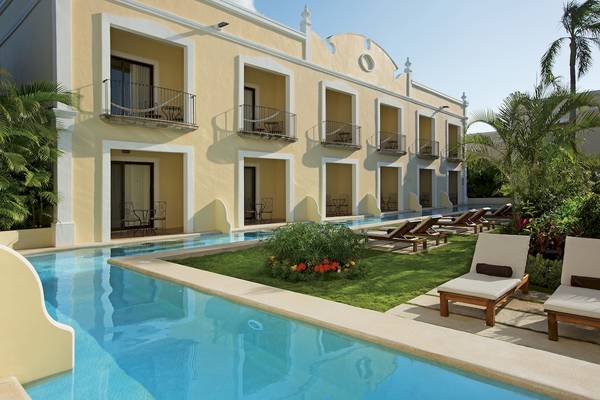 Außenbereich des Dreams Tulum Resort & Spa mit Pool und Liegen.