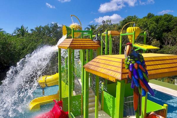 Wasserspielplatz im Dreams Tulum Resort & Spa mit Wasserrutschen und buntem Papagei