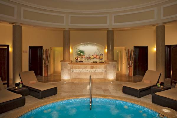 Pool-Loungebereich im Dreams Tulum Resort & Spa mit Sonnenliegen und einer Theke.