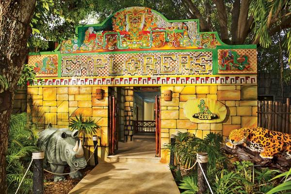 Eingang des Explorer's Club mit bunter Maya-Dekor und Statuen von Nashorn und Jaguar.