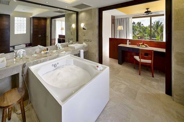 Luxuriöses Badezimmer im Barcelo Maya Grand Resort mit Badewanne, Waschtischen und Ausblick.