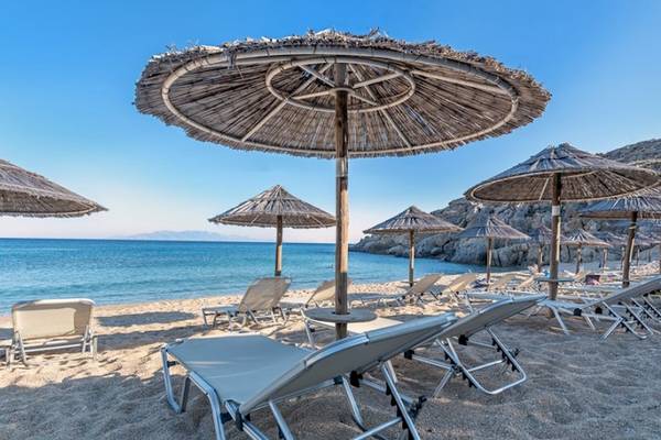 Strand mit Sonnenschirmen und Liegen am Sunrise Mykonos Hotel