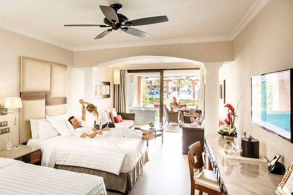 Suite im Barcelo Maya Grand Resort mit zwei Betten, Wohnzimmer und Terrasse.