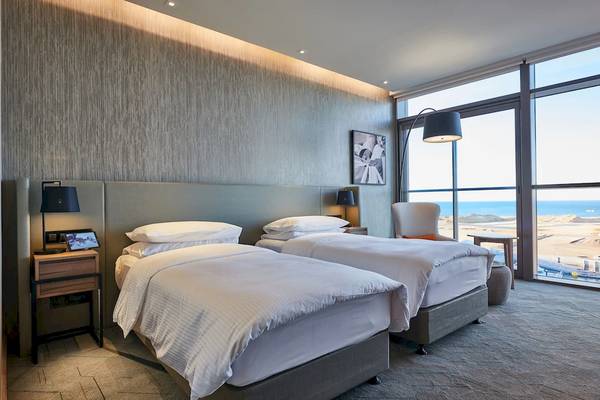 Zwei Betten im Hotelzimmer von Mysk Al Mouj mit Meerblick