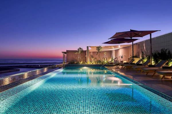 Schwimmbad und Loungebereich des Mysk Al Mouj Hotels bei Sonnenuntergang