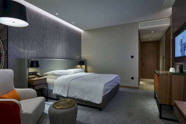 Mysk Al Mouj Hotelzimmer mit Bett, Nachttisch und Stuhl.