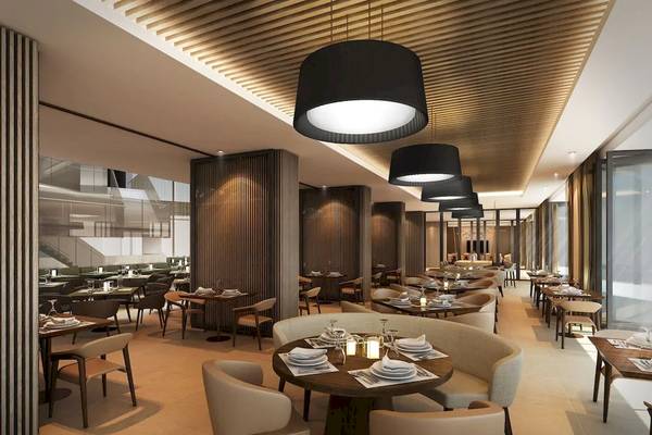 Innenansicht des Restaurants im Mysk Al Mouj Hotel mit modernen Möbeln und warmer Beleuchtung.