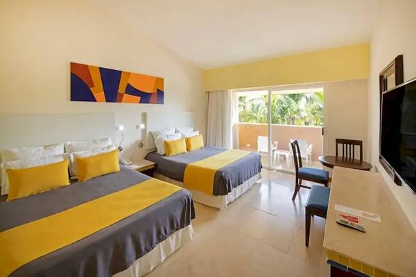 Doppelbettzimmer im Viva Azteca by Wyndham mit Blick auf einen Balkon und Terrasse.