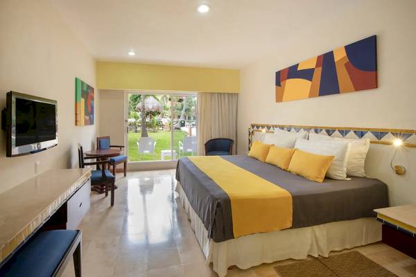 Viva Azteca by Wyndham Hotelzimmer mit Doppelbett, Fernseher und Ausblick auf Garten