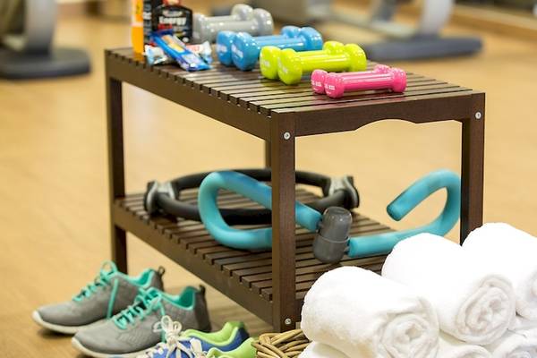 Fitness-Zubehör im Universal Hotel Neptuno, einschließlich Hanteln, Fitnessbändern und Handtüchern.