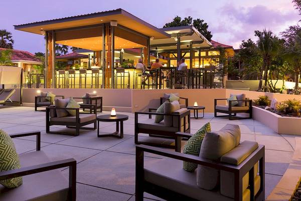Terrasse des Dewa Phuket Resort & Villas mit Sitzgelegenheiten und einer Bar.