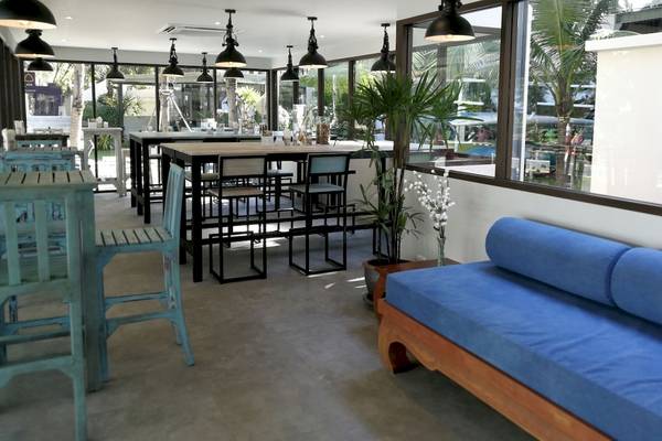 Innenbereich des Dewa Phuket Resort & Villas mit Lounge-Sitzbereich und Tischen.