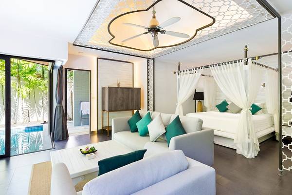 Wohnzimmer des Dewa Phuket Resort & Villas mit Bett, Sofas und Deckenventilator