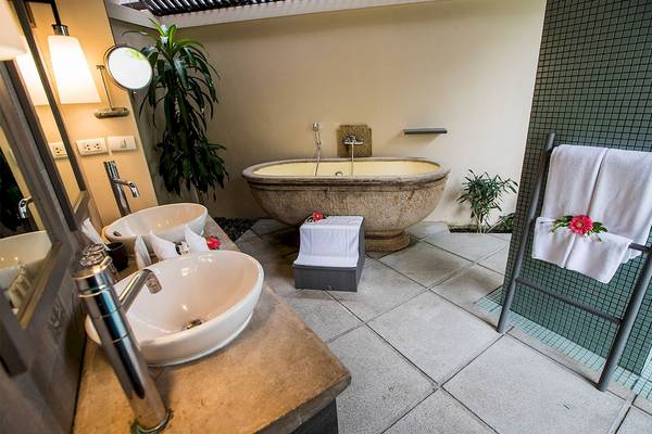 Badezimmer im Dewa Phuket Resort & Villas mit freistehender Badewanne, Waschbecken und Handtüchern.