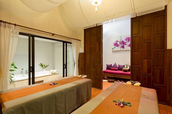 Spa-Behandlungsraum im Dewa Phuket Resort & Villas mit zwei Massageliegen und einer Badewanne.