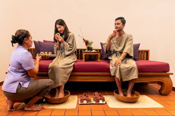Drei Personen im Dewa Phuket Resort & Villas genießen eine Fußmassage.