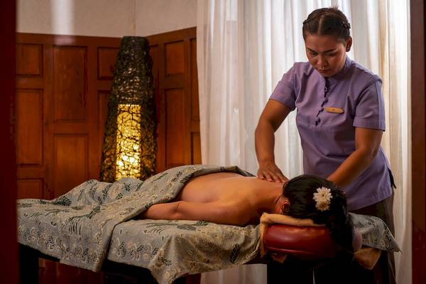 Eine Frau im Dewa Phuket Resort & Villas, die eine Massagebehandlung durchführt.