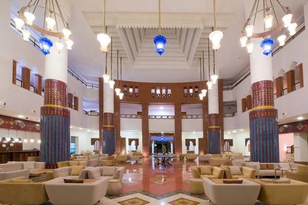 Lobby des Iberostar Founty Beach Hotels mit blauen Kronleuchtern, runden Tischen und Sofas.