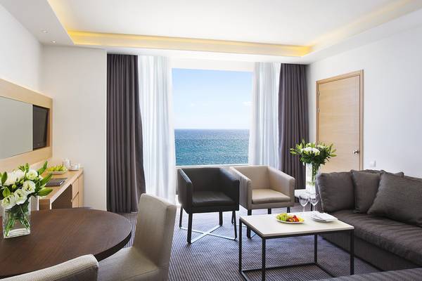 Innenansicht der Suite im Royal Apollonia Beach Hotel mit Blick auf das Meer.
