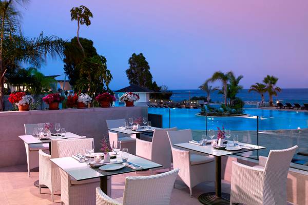 Außenterrasse des Royal Apollonia Beach Hotel mit Blick auf den Pool und das Meer.